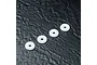 Four white circular MST machined shock pistons arranged diagonally on a dark textured surface.