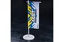 A miniature MST branded banner flag on a white plastic stand against a dark background.