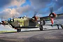 Digital illustration of a B-24J Liberator bomber named Witchcraft taxiing on an airfield with other bombers in the background.
