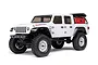 A white Axial SCX24 Jeep Gladiator RC rock crawler shown from a front three-quarter angle against a white background.