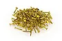 A pile of small brass pins for modelling, scattered on a white background.