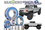 A collection of metal ball bearings with blue rubber seals arranged in front of two silver Element RC Utron SE scale model trucks.