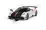 A studio shot of a Scalextric 1/32 scale Pagani Huayra BC Roadster slot car in pearl white and black with red accents, positioned on a slot car track.