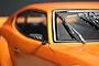 Close-up of a carbon fiber style side mirror mounted on an orange 1/10 scale RC car body.
