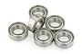 A cluster of six silver metal shielded ball bearings arranged on a white background.