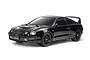 A studio shot of a black Tamiya Toyota Celica GT-Four ST205 RC car model on a white background.
