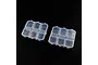 Two clear plastic storage boxes with six individual compartments each, set against a plain black background.